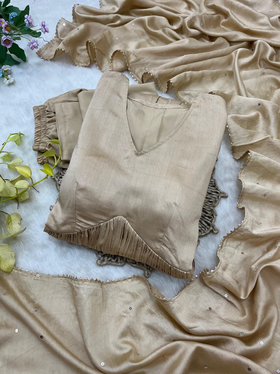 Beige velvet top with ruffled details on a textured surface with green leaves. Beige Anarkali Suit Set Roohri 