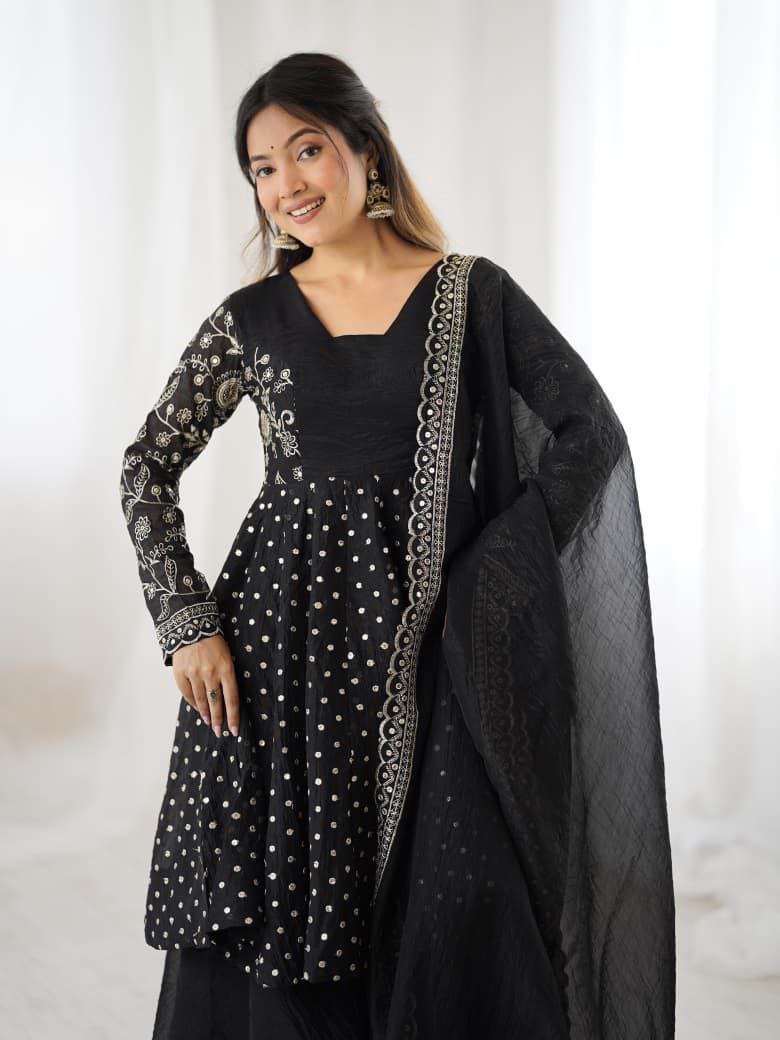Woman wearing a black traditional outfit with white patterns on a light background Black Sharara Suit Set Roorhi