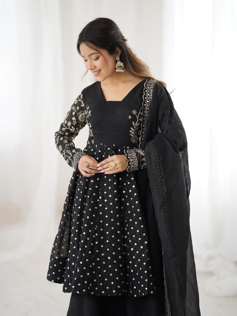 Woman wearing a black traditional outfit with white patterns on a white background Black Sharara Suit Set Roorhi