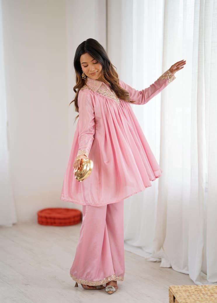 Woman wearing a pink traditional outfit with gold accents in a bright room. Pink Co-ord Set