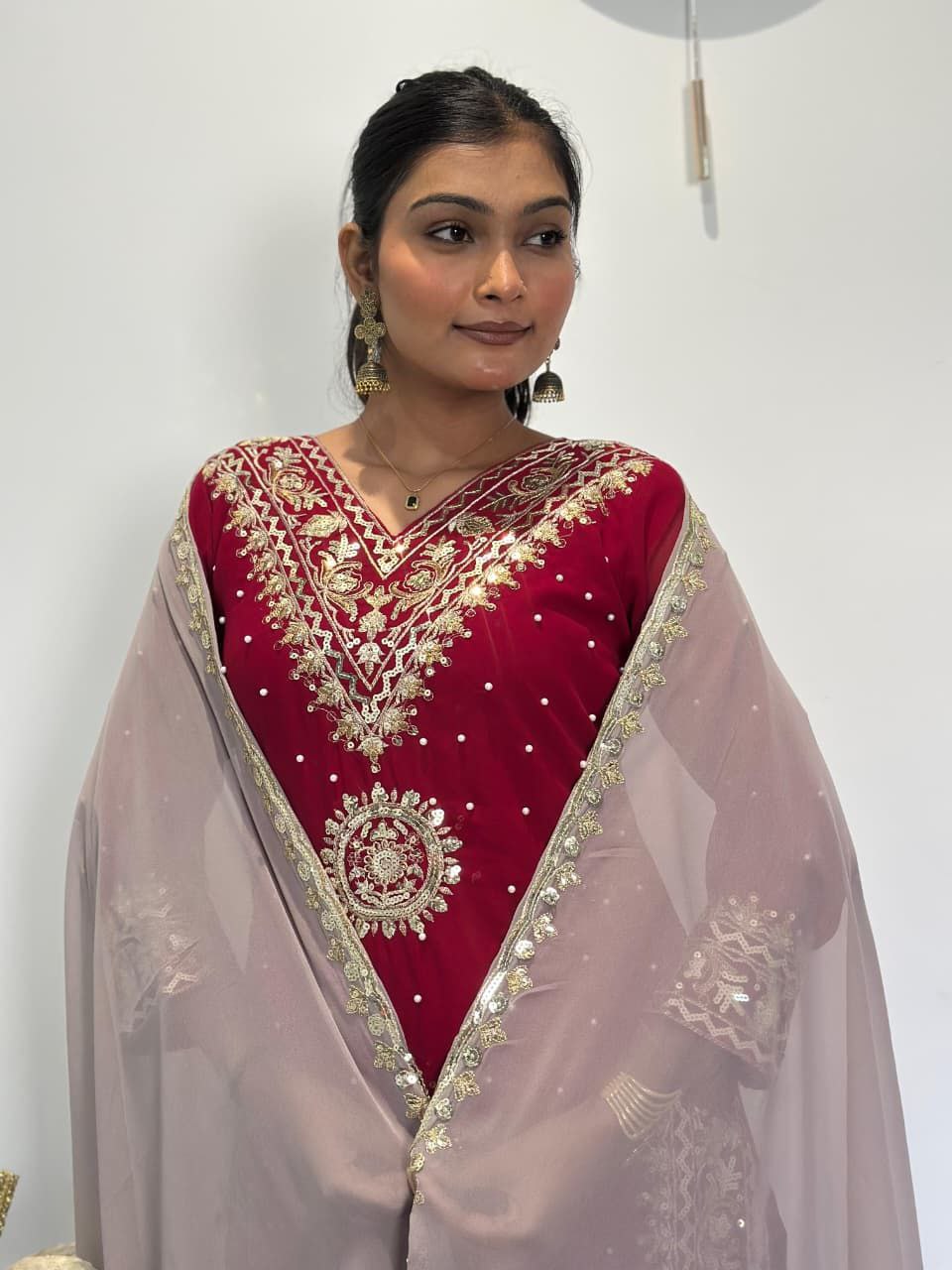 Woman wearing a red embroidered outfit with a beige dupatta against a white background Red Palazzo Suit Set Roohri