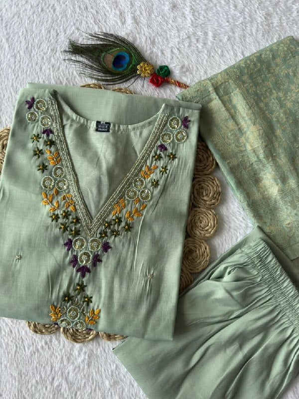 Light green embroidered outfit with peacock feather and flowers on a textured white background sea green suit set roohri