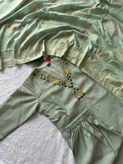 Green fabric with embroidered details on a textured surface sea green suit set roohri